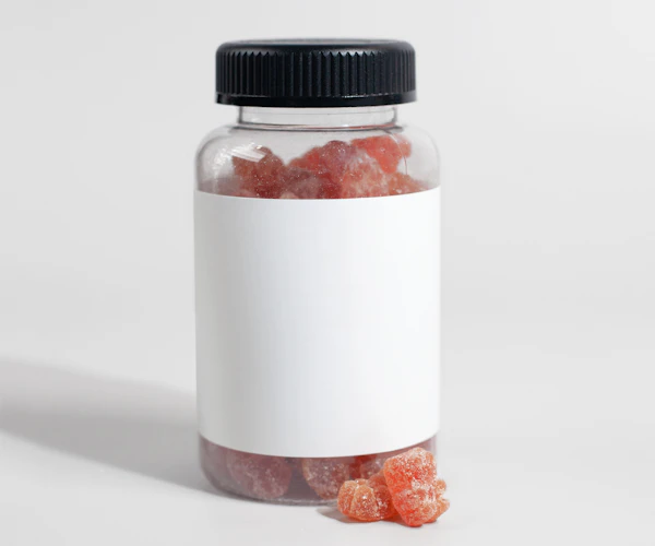 Pote transparente com gomas avermelhadas e rótulo em branco